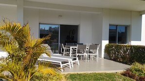 Eine moderne Außenpatio mit Esstisch und einer großen Glasschiebetür, die in einen Innenraum führt.