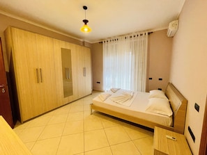 Ein Hotelzimmer mit Bett, Kleiderschrank, Nachttisch und einer Pendelleuchte.
