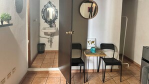 A bathroom with a sink, mirror, and a small table with chairs.