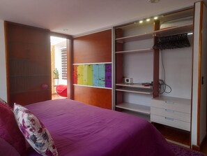 Une chambre à coucher avec un lit, une armoire et un bureau.