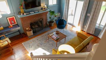 Smart TV, chimenea, libros y biblioteca musical