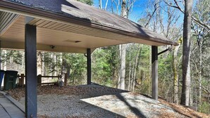 A covered outdoor area with a gravel floor, surrounded by trees.