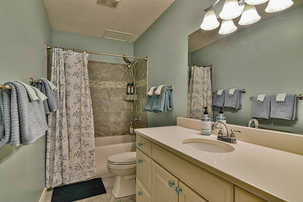 A bathroom with a bathtub, toilet, and sink.