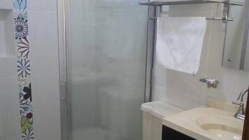 Un bagno con doccia, WC, lavandino e porta asciugamani.