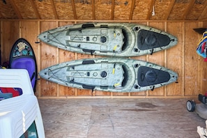 Two kayaks stored horizontally in a wooden room with a sloped ceiling. - Fish, Hike & Hunt: Lakeside Newaygo Cottage (Newaygo)