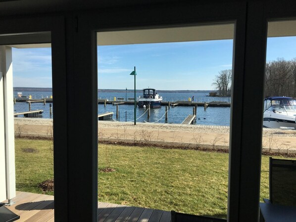 A view from inside a building looking out to a marina with boats docked, a grassy area, and a clear sky. - Gemütliches Zweizimmer Apartment , Direkt am Hafen Haus 6 / Apartment 3 - Gemütliches 2-zimmer (Plau am See)