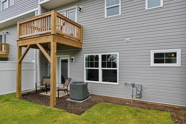 A two-story house with a wooden deck, a covered patio, and a large air conditioning unit. - Mtn View Townhome, Sleeps 8 (Candler)