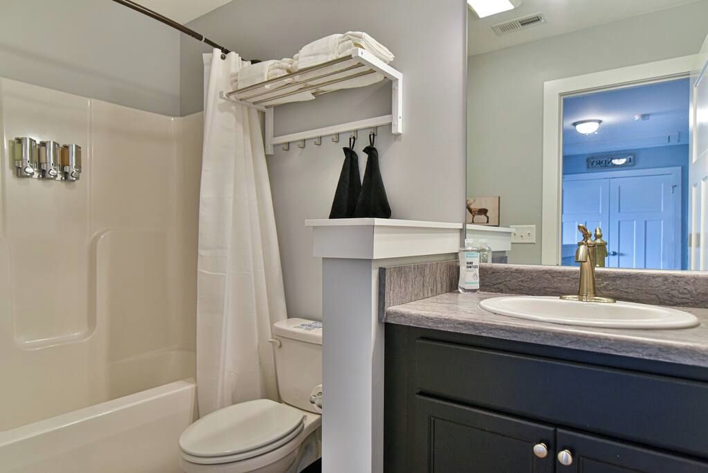 A bathroom with a shower, toilet, and sink.