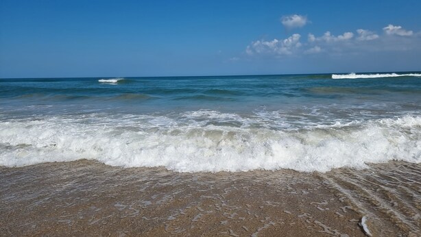 A beach with waves gently crashing onto the shore under a clear sky. - Screened Heated Pool, Boat Ramp Nearby, Beaches (Port St Lucie)