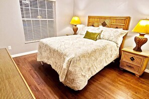Una camera da letto con un letto, due lampade da comodino, un comodino in legno e una finestra con persiane.