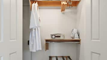 Lavanderia compacta e bem iluminada, com um banco de madeira, varal e prateleira com ventilador e outros objetos.