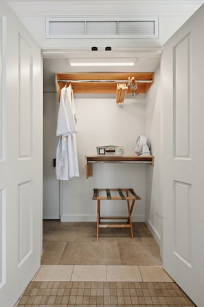 A compact, well-lit laundry room with a wooden bench, a drying rack, and a shelf with a fan and other items. - Chic Resort Escape| King Bed + Fireplace + Kitchen (Napa)