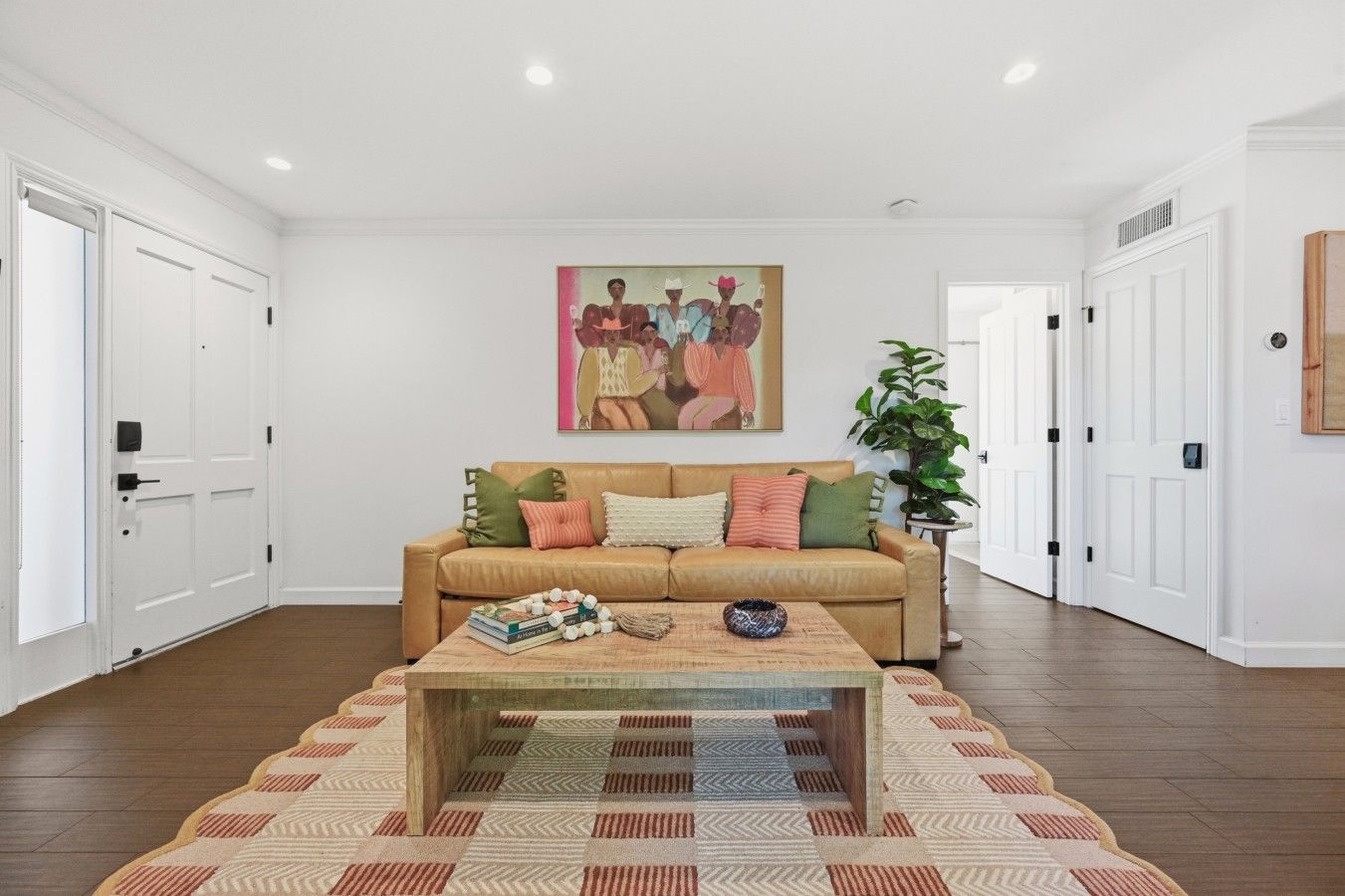 Ein Wohnzimmer mit einem beigen Sofa, einem Couchtisch und einem Bild an der Wand.
