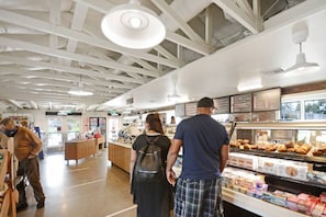 A bakery interior with a central counter, display cases, and a seating area.