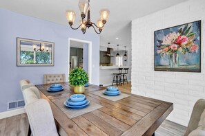 A dining area with a wooden table, blue plates, and a potted plant.