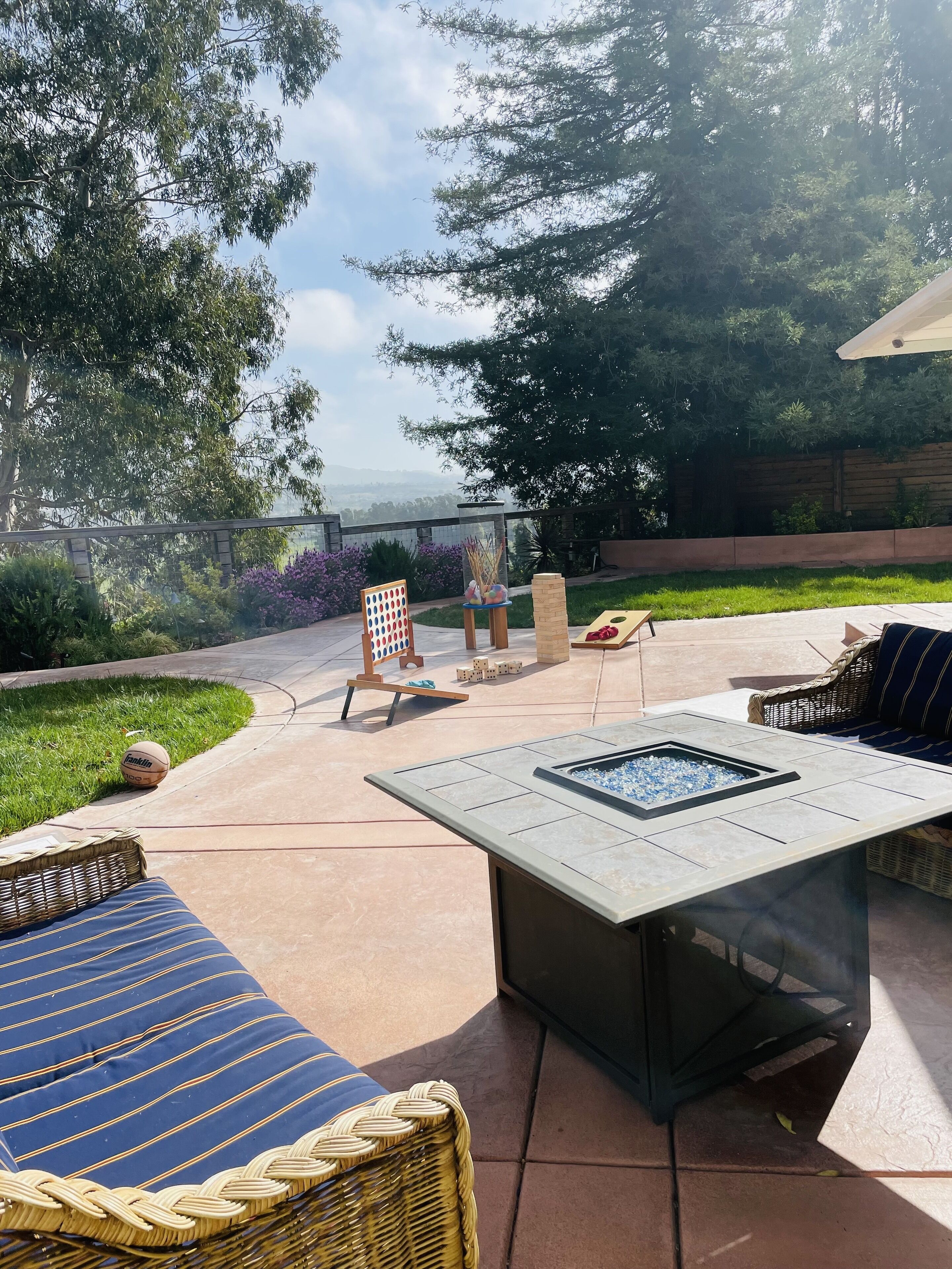 An outdoor patio with a fire pit, seating area, and a children's play area.