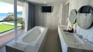 Un bagno moderno con una vasca da bagno ampia, due lavabi e un grande specchio.
