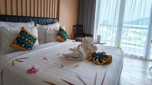 Camera d'albergo con un letto grande, pareti in legno, vista sull'esterno e zona pranzo con tavolo e sedie.