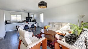 Et moderne køkken med spiseplads, en sofa og et sofabord.
