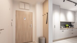 Une cuisine moderne avec des meubles blancs, un pare-feu en marbre et un petit îlot central.