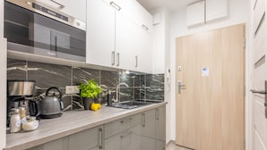 A modern kitchen with a built-in oven, a kettle, and various kitchen items on the counter. - Vacation apartment by the sea, vacation on the island of Usedom, Apartment MATEJKI 4 (Swinoujscie)