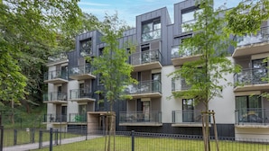 A modern multi-story building with balconies, surrounded by trees and a fenced courtyard. - Vacation apartment by the sea, vacation on the island of Usedom, Apartment MATEJKI 4 (Swinoujscie)