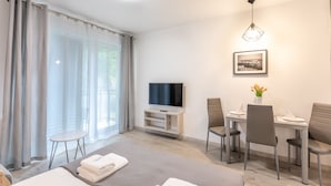 A modern hotel room with a bed, a small table, a TV, and a dining area with chairs. - Vacation apartment by the sea, vacation on the island of Usedom, Apartment MATEJKI 4 (Swinoujscie)
