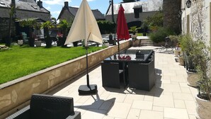 Un área de patio exterior con mobiliario, mesa de billar y sombrillas.
