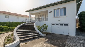 A two-story house with a curved staircase leading to a balcony.