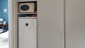 A compact kitchen with a built-in microwave and a refrigerator. - Vacation home close to the beach (La Faute-sur-Mer)