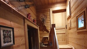 Un interior de madera con una escalera que sube a un segundo piso.