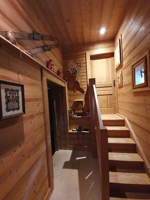 A wooden interior with a staircase leading to a second floor.