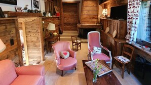 Un interior rústico de madera con chimenea, muebles de madera y un televisor.