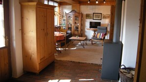Un salón acogedor con muebles de madera, suelo de ladrillo y chimenea.