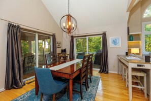 A dining area with a wooden table, chairs, and a chandelier.