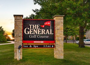 Un panneau indiquant le terrain de golf « The General Golf Course », avec une flèche pointant vers la droite, indiquant la direction de l’auberge et du spa.
