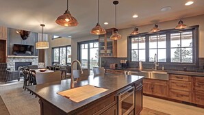 A modern kitchen with a large island, stainless steel appliances, and pendant lighting. - Happy Hour Hideaway - Mountaintop views! (Lead)