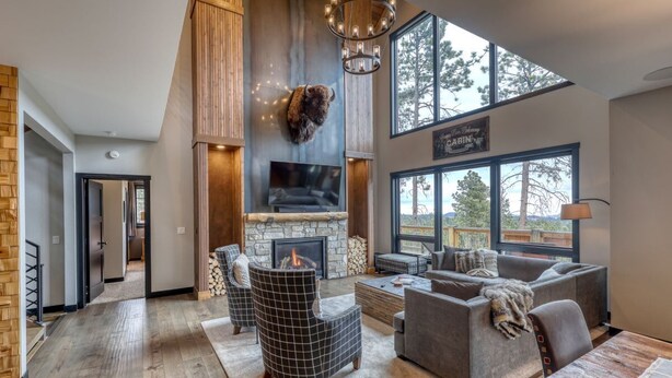 A spacious living room with a stone fireplace, a large TV, and a cozy seating area. - Happy Hour Hideaway - Mountaintop views! (Lead)
