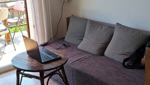 A living area with a sofa, a round table, and a laptop. - Sea view apartment.
Walking distance to the beach, and  the amazing cliffs. (Tossa de Mar)