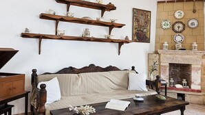 A traditional living room with a sofa, wooden coffee table, and decorative shelves. - Elia (Patmos)