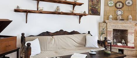 Un salón tradicional con sofá, mesa de centro de madera y estanterías decorativas.