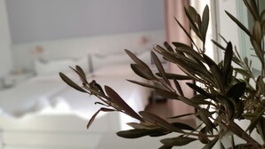 A room with a bed, a bedside table, and a potted plant. - Elia (Patmos)