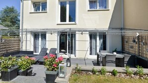 A two-story house with a covered patio area featuring outdoor furniture and potted plants. - House 120 m² in Vigy (Vigy)