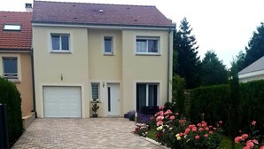A two-story house with a paved driveway leading to a garage. - House 120 m² in Vigy (Vigy)