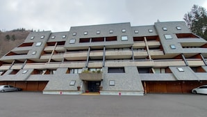 Ein mehrstöckiges Gebäude mit einzigartigem architektonischen Design, inklusive Balkonen und einem zentralen Eingang.