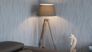 Una sala de estar moderna con un sofá gris, una lámpara de pie y una escultura decorativa de caballito de mar.