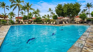 A swimming pool with clear blue water, surrounded by palm trees and lounge chairs. - KKSR#2304 DIRECT OCEANFRONT, INCREDIBLE TOP FLOOR CORNER UNIT, HUGE LANAI! (Kailua Kona)