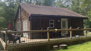 A wooden cabin with a deck, surrounded by trees. - Beautiful Cabin in the woods  Allegany County NY (Belmont)
