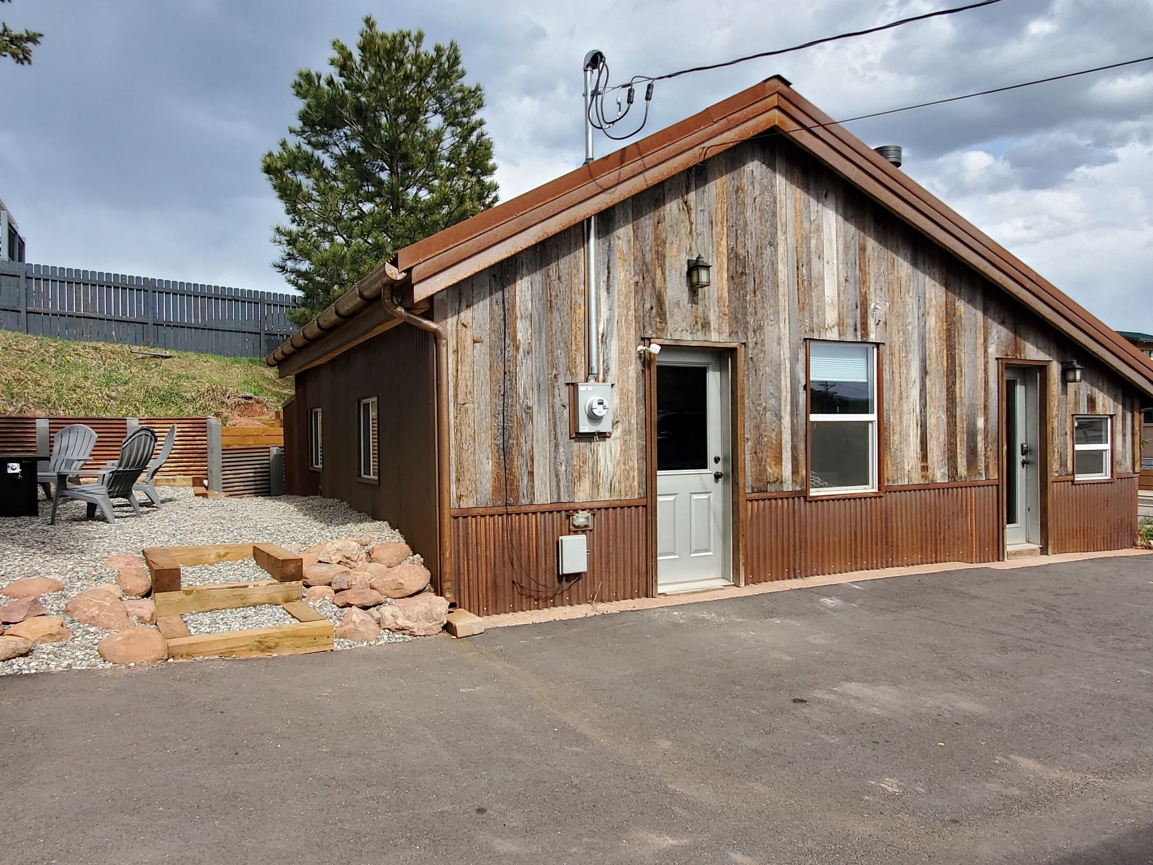 A rustic wooden building with a sloped roof, a front door, and a window.