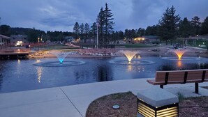 A tranquil outdoor setting with a water feature, benches, and a well-lit pathway. - Pikes Peak Views: One Block to Downtown (Woodland Park)